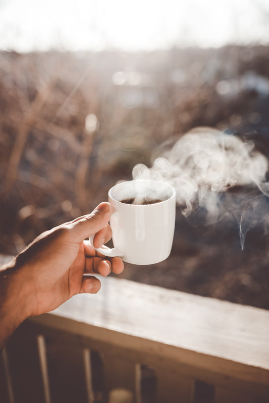 Someone is raising a mug of pour over coffee